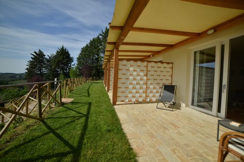 Terrazza con vista giardino presso Villa Clara B&B ad Assisi con pergolato in legno, sedie a sdraio e paesaggio rurale