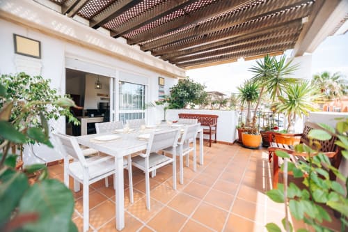 Stromboli triplex terrace at BH Marbella with dining table, sea view, and Mediterranean plants under pergola
