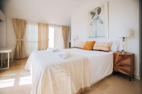 Bright bedroom in Stromboli triplex at BH Marbella with twin beds, wooden nightstand, sea-view balcony and modern amenities