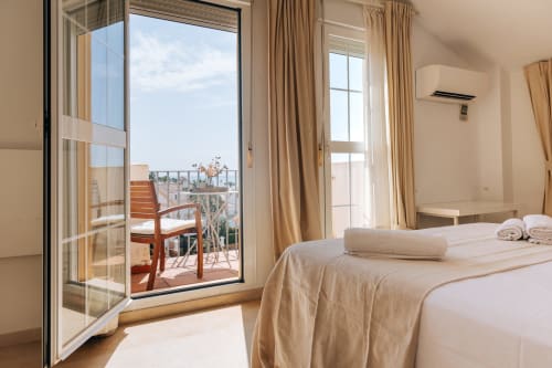 Bright bedroom in Stromboli triplex apartment at BH Marbella with sea view balcony and modern amenities