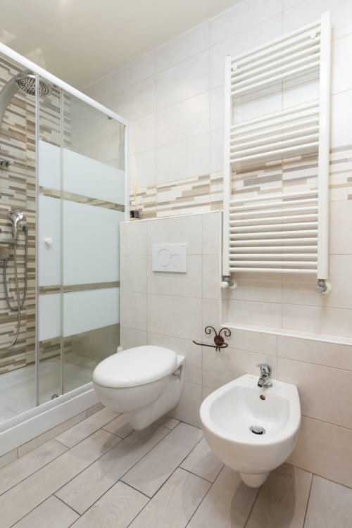 Moderno bagno nella camera Lina di Casa Scola Loano B&B, con piastrelle bianche, wc, bidet, box doccia e riscaldamento