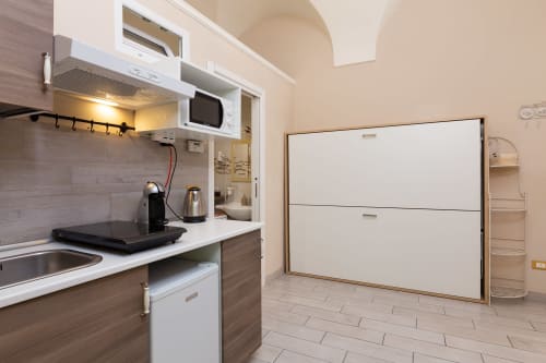 Monolocale Lina con angolo cottura presso Casa Scola Loano BnB: lavandino, microonde, caffettiera e letto matrimoniale pieghevole