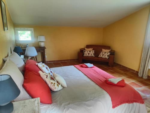 Spacieuse chambre au Domaine Bellavigne Gîtes et Spa avec murs jaunes, lits jumeaux et mobilier en bois à Forcalquier