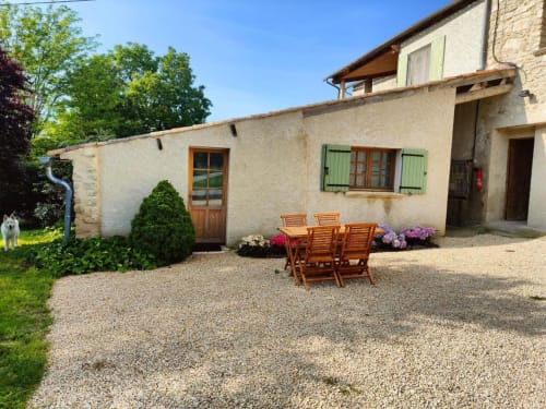 Cour du gîte du Domaine Bellavigne à Forcalquier avec transats en bois et plantes fleuries