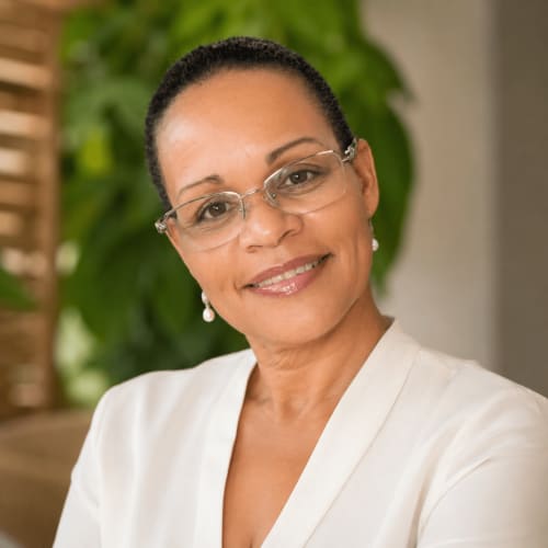 Professional portrait of a woman wearing glasses and cream blazer at El Litoral Wellness Retreat, Coronado PA