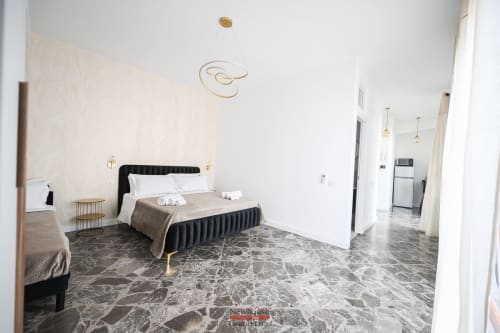 Appartamento Cavour Deluxe a Bari: camera da letto spaziosa con letto nero, pavimento in marmo, arredamento moderno