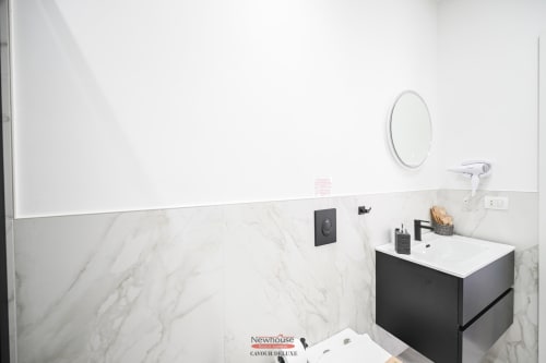 Bagno moderno nell'appartamento Newhouse Cavour Deluxe a Bari con pareti in marmo, lavabo bianco e specchio