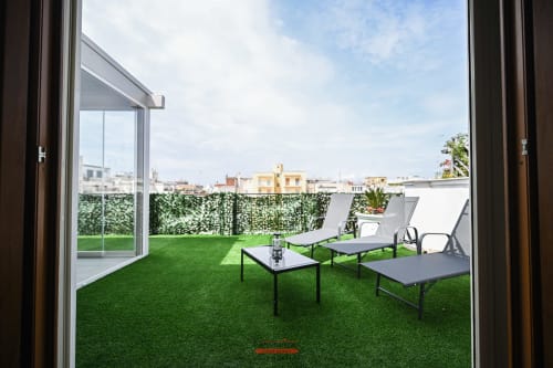 Balcone dell'appartamento Cavour Deluxe con erba sintetica, lettini e vista sul panorama di Bari al Newhouse hotel