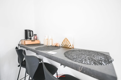 Moderna area di lavoro nell'appartamento Newhouse Cavour Deluxe a Bari con scrivania, sedie grigie e macchina da caffè