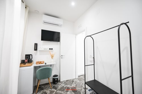 Moderna camera Cavour Deluxe all'hotel Newhouse Bari con zona di lavoro, TV a parete, aria condizionata e attaccapanni nero