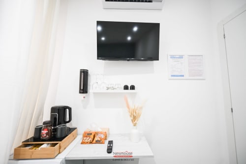 Camera Deluxe Newhouse Cavour a Bari con TV a parete, scaffali bianchi, macchina per caffè e vista sulla città