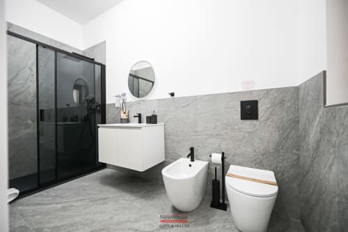 Bagno moderno nella camera Newhouse Cavour Deluxe di Bari con rivestimenti in marmo, mobile sospeso e finiture nere