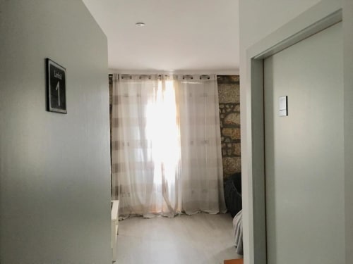 Quarto moderno na Estação Boutique Campanhã no Porto com cortinas translúcidas, paredes brancas e decoração minimalista