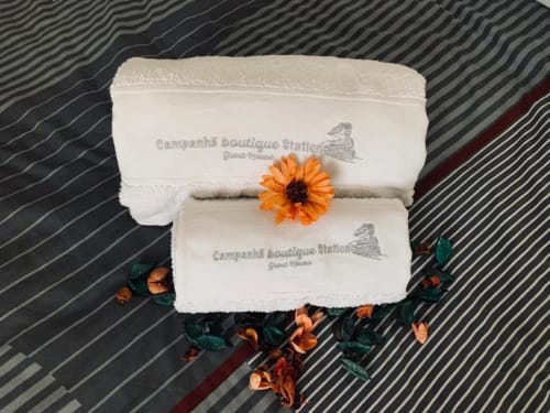 Toalhas brancas com logotipo da Estação Campanhã, decoradas com gerbera laranja, Porto Portugal