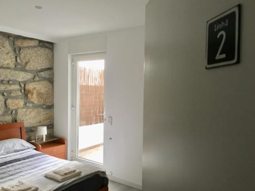 Linha 2 bedroom at Campanhã Boutique Station in Porto with stone accent wall, bed, terrace access, and modern amenities