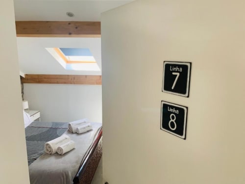 Linha 7 & 8 room at Campanhã Boutique Station in Porto with skylight, wooden beams, and rolled towels on bed