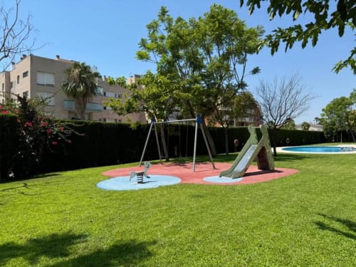 Playground with swing set and slide in Rentalaya apartment garden, Salou Spain