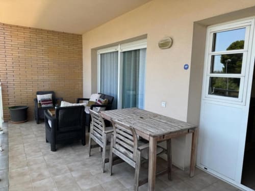Spacious terrace at Renatalaya Salou apartment with dining table, seating area, and garden views
