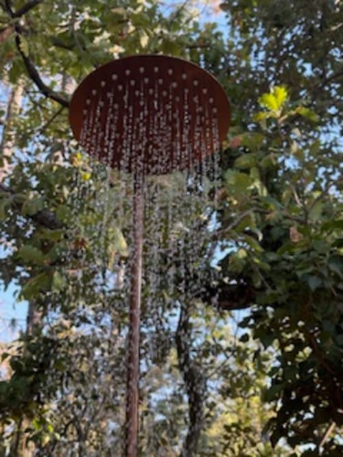 Douche de jardin à la Lou Paradou Lodge Grillon, entourée d'une végétation luxuriante