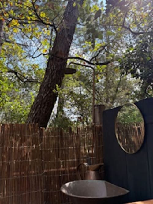 Jacuzzi sur la terrasse du jardin du Lou Paradou Lodge à Grillon, entouré d'arbres et de verdure