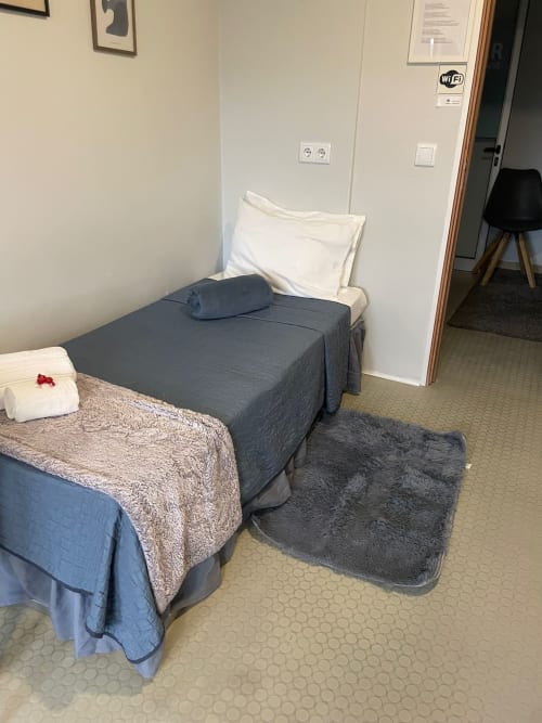 Chambre triple avec douche à la Liber Guest House à Braga, équipée de deux lits et WiFi