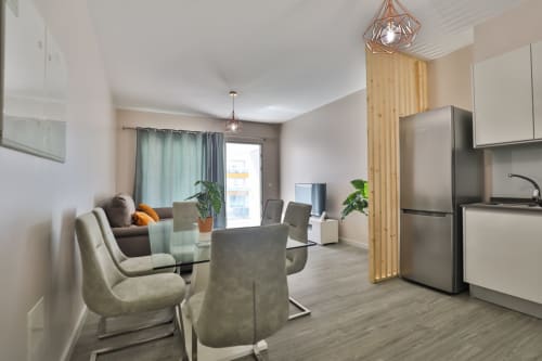 Sala de estar e jantar moderna com cozinha, eletrodomésticos em aço inoxidável e confortáveis assentos na Rent-A-Key