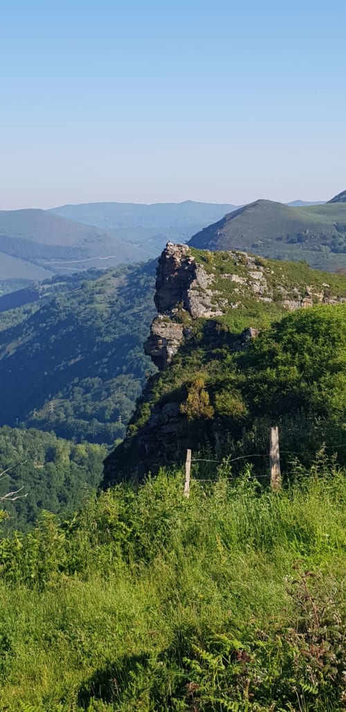 Dramatic rocky peak overlooks lush valley near Posada La Colodra in Los Tojos, Spain
