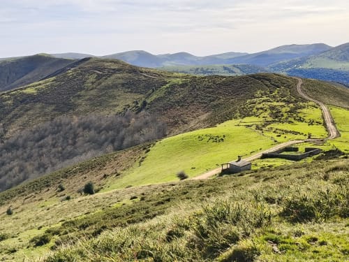 Posada La Colodra nestled in green rolling hills of Los Tojos, Spain, surrounded by mountains and lush valleys
