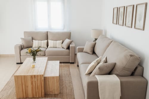 Bright living room at Alojamientos Estrella Baeza with beige sofas, wooden table, and mountain view in Baeza