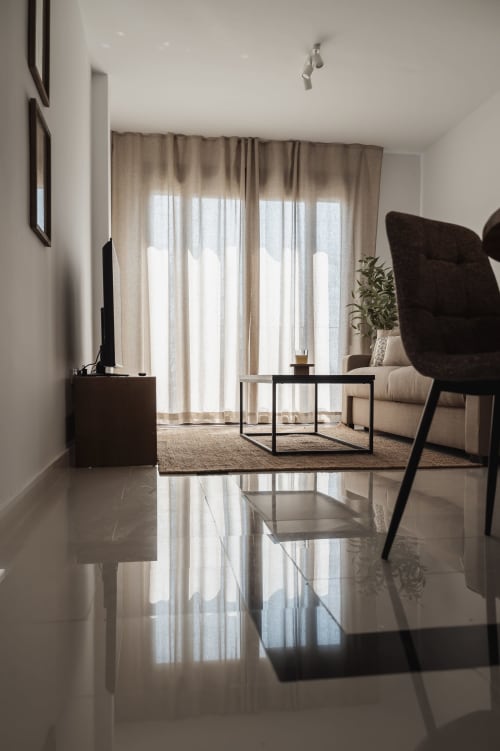 Modern living room at Alojamientos Estrella Baeza with polished floors, contemporary furniture, and mountain views through