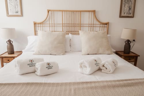 Welcoming bedroom at Estrella Baeza hotel with rolled towels, wooden headboard, and neutral décor in Baeza, Spain