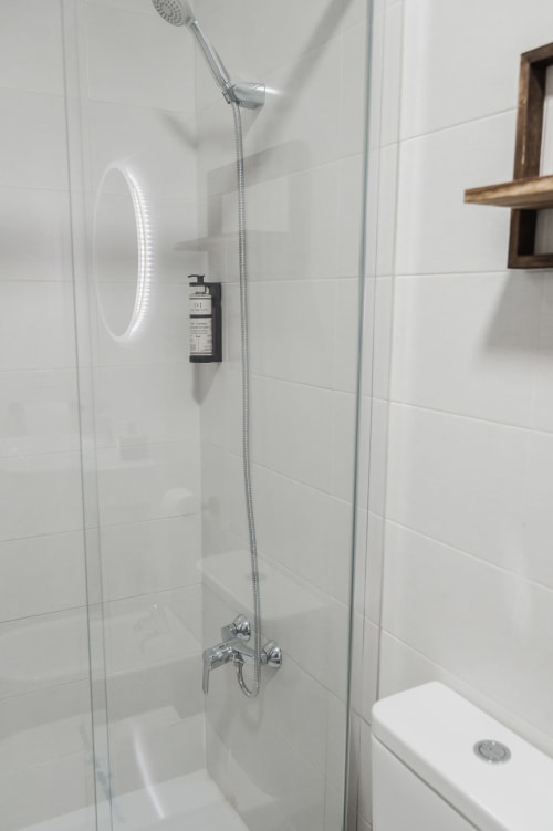 Modern shower enclosure with rainfall showerhead and chrome fixtures in Alojamientos Estrella Baeza apartment bathroom, Baeza