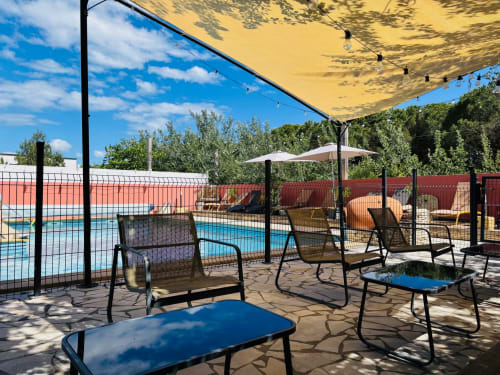 Poolbereich des Entre 2 eaux B&B in Marseillan-Plage mit Liegestühlen, gelbem Sonnenschirm und glitzerndem Pool