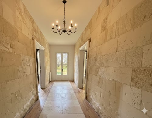 Corridor en pierre du Château Alto Cormeil à Saint-Émilion avec lustre, parquet et portes-fenêtres