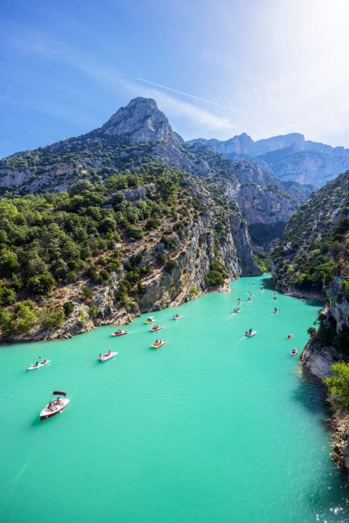 Lac turquoise entouré de falaises calcaires et bateaux près des Salles-sur-Verdon, France