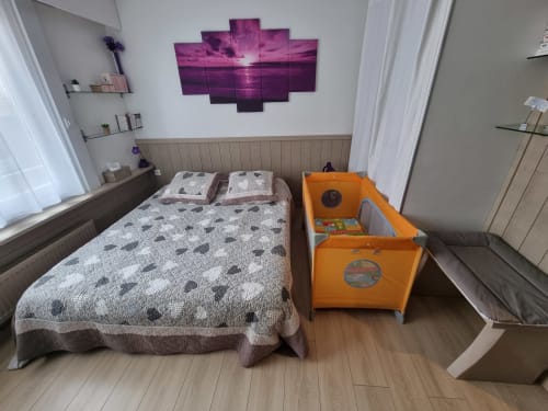 Chambre moderne à Zoppas Aix-les-Bains avec lit queen, œuvre coucher de soleil violet, parc orange et décor épuré