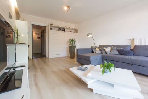 Studio moderne à Zoppas Aix-les-Bains avec séjour ouvert, canapé bleu, kitchenette blanche et parquet