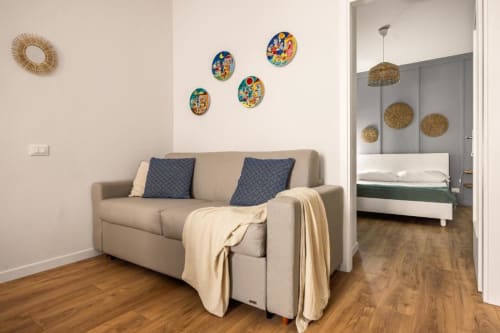 Beige sofa with blue pillows in living room of Dimora Silva Nature Suites apartment, San Martino delle Scale, with decorative