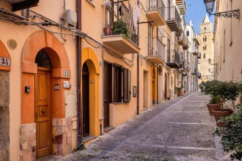 Charming historic street in San Martino delle Scale with colorful doors and stone architecture, featuring landmark church