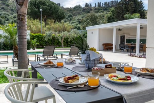 Tavolo colazione all'aperto con vista sulla piscina privata e giardino della villa Dimora Silva Nature Suites in Sicilia