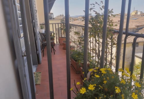 Balcony with yellow flowers overlooking Florence rooftops at Hotel Genzianella, city view room with terrace access
