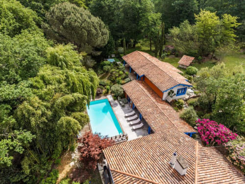 Vue aérienne de l'hôtel Le Moulin De Lassalle à Linxe avec piscine, toits en terre cuite et jardins luxuriants