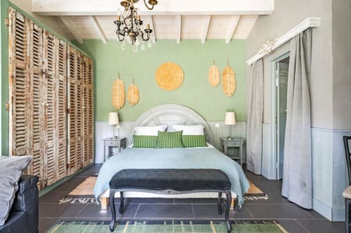 Chambre moderne du Moulin De Lassalle aux murs vert menthe, lit blanc, décor feuille d'or et volets bois à Linxe.