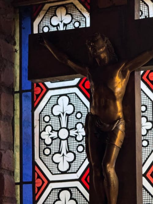 Crucifix à côté d'une verrière aux fleurs de lys au Moulin de Lassalle, Linxe