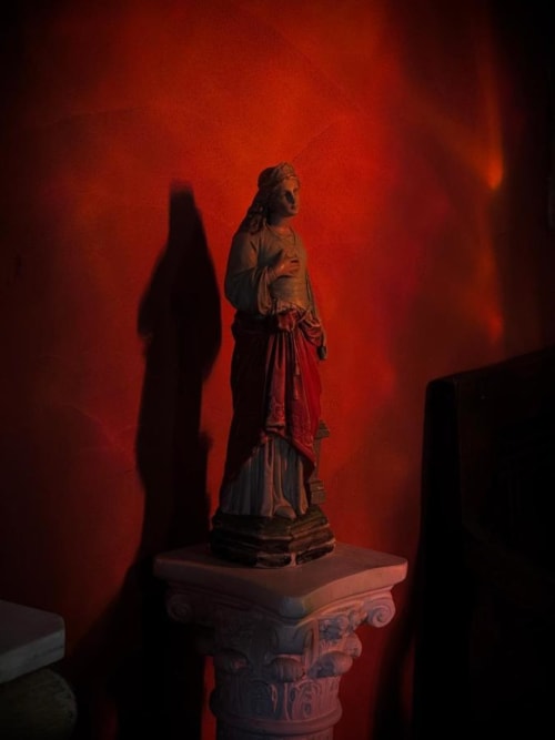 Statue classique sur piédestal orné avec éclairage atmosphérique rouge à l'hôtel Le Moulin De Lassalle à Linxe
