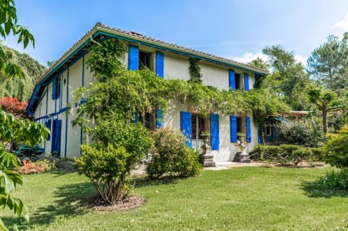 Le Moulin De Lassalle à Linxe, France - charmante maison en pierre blanche avec volets bleus et jardins luxuriants