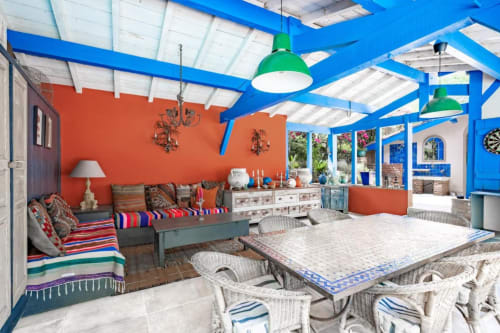 Élégante terrasse extérieure au Moulin De Lassalle à Linxe avec poutres bleues, mobilier coloré et espace repas