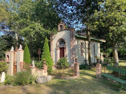 Chapelle en pierre historique du Moulin De Lassalle à Linxe, France, entourée d'arbres verdoyants