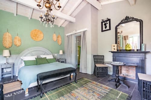 Chambre élégante du Moulin De Lassalle avec mur d'accent vert menthe, lustre orné et cheminée à Linxe
