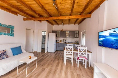 Apartamento Los Olivos en Smart Rent Fuerteventura con vigas de madera, cocina, comedor y sofá en Tarajalejo